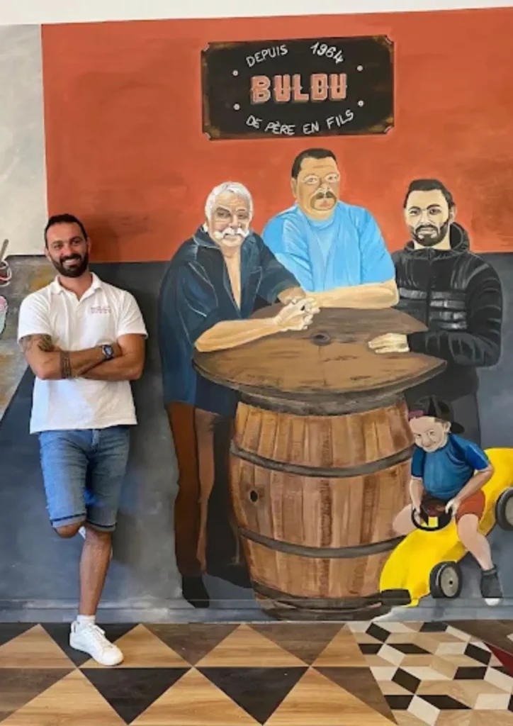 Artisan peintre cedric Buldu devant fresque murale personnalisée